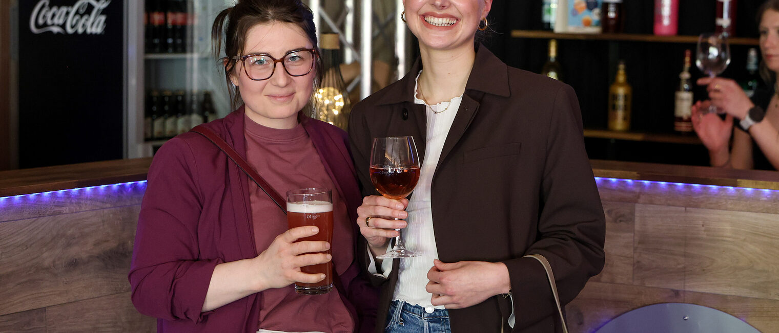 Gäste der Podiumsdiskussion trinken gemeinsam etwas.