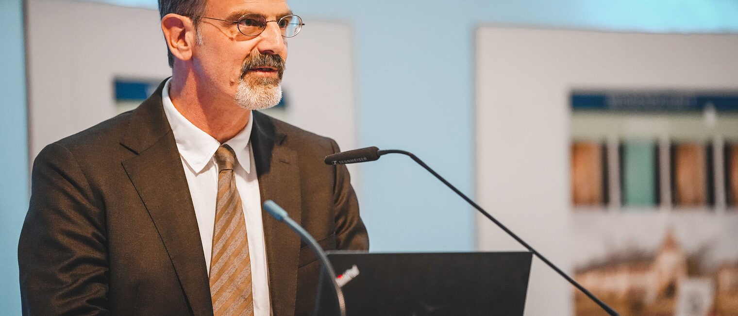 Professor Breitling hält einen Vortrag am Rednerpult.