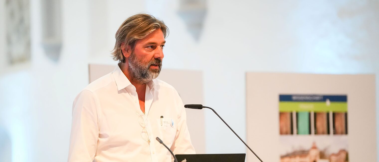 Professor Schlempp hält einen Vortrag am Rednerpult.