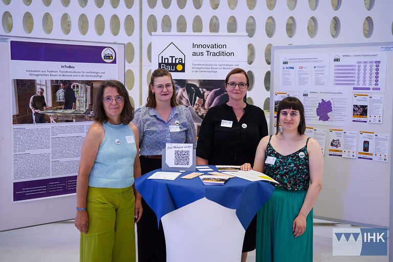 Gruppenbild von Mitarbeiterinnen des Projekts InTra Bau an einem Infostand.