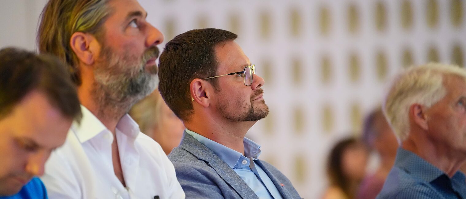 Andreas Kätzel und Professor Schlempp hören einem Vortrag zu.