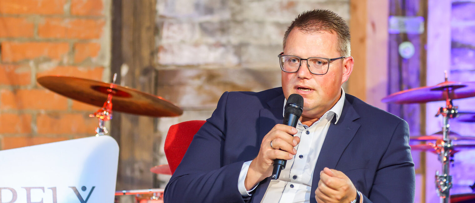 Holger Grießhammer spricht auf dem Podium in ein Mikrofon.