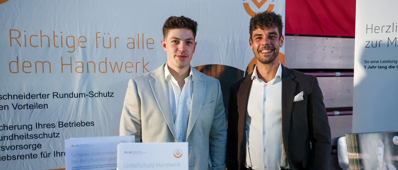 Zwei Mitarbeiter des Münchner Vereins stehen an ihrem Stand.