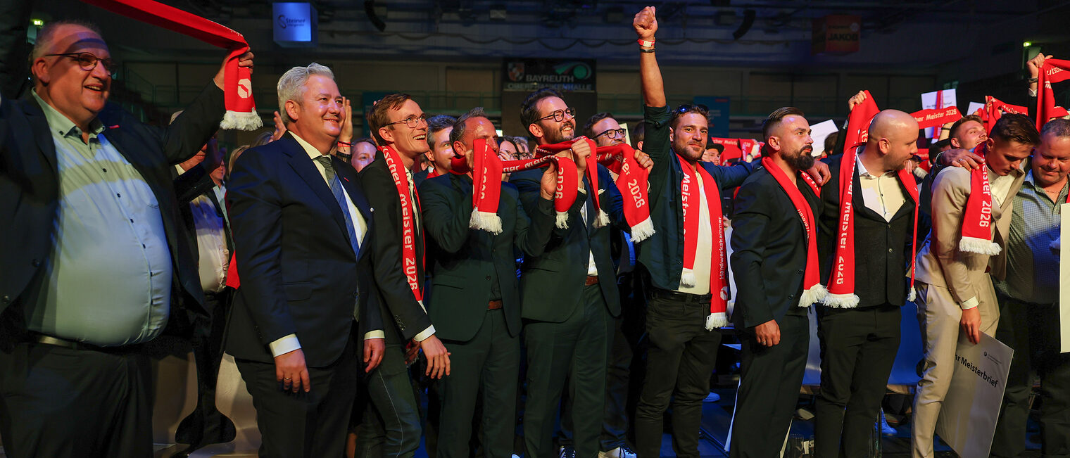 Matthias Graßmann und Reinhard Bauer feiern mit den Meistern und Meisterschals.