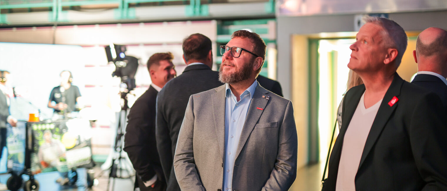 Karl-Michael Hopf und ein anderer Gast folgen dem Geschehen.