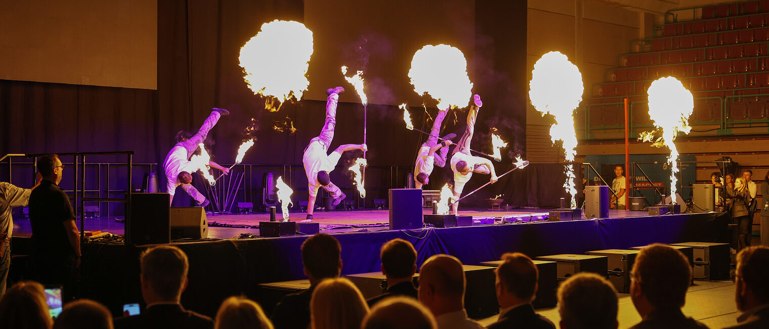 Die Magic Artists führen ihre Bühnenshow mit Feuerelementen auf. 