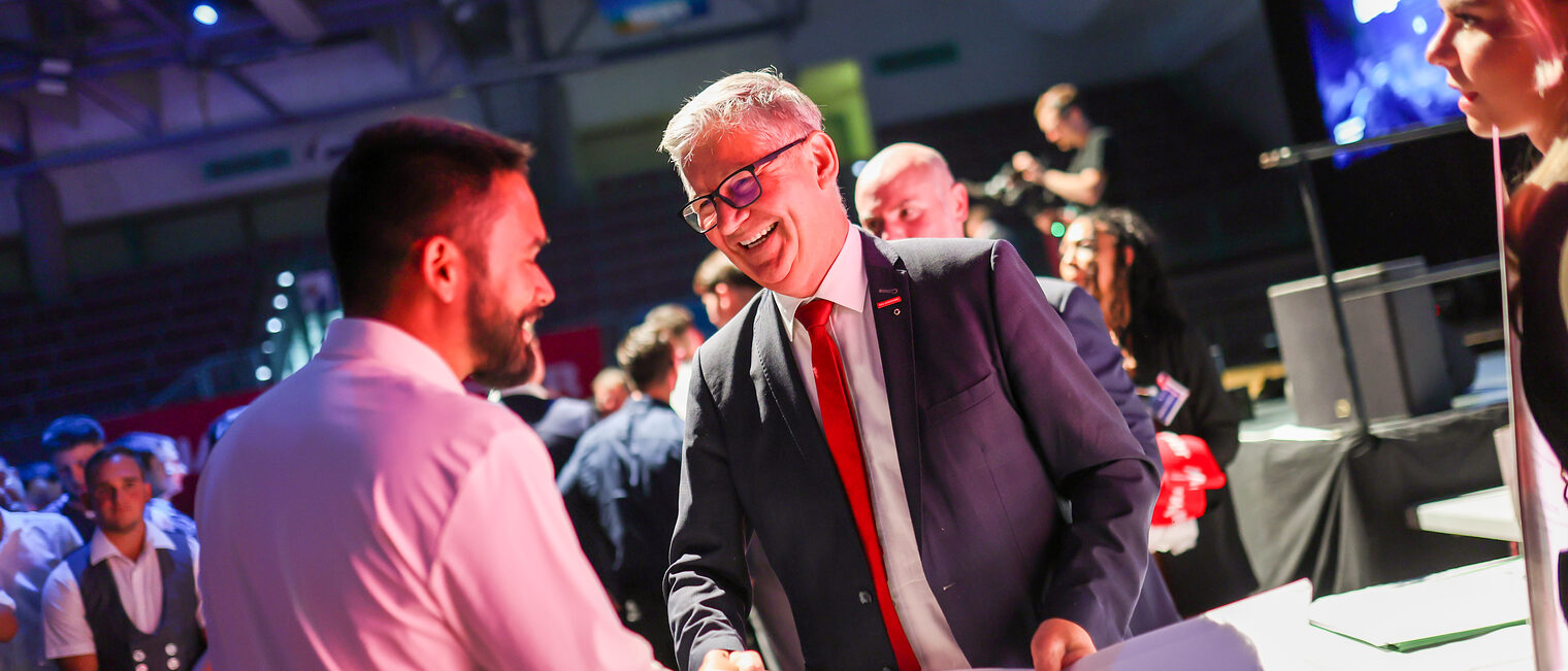 HWK-Vizepräsident Christian Herpich übergibt den Meisterbrief an einen Jungmeister.