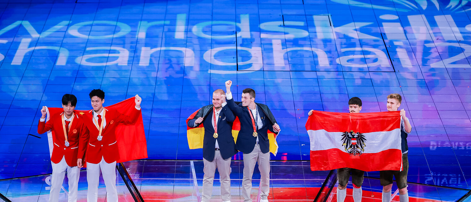 Jakob Distler und Tim Arnold stehen auf Platz 1 auf dem Siegertreppchen neben den Platzierten aus China und Österreich. 