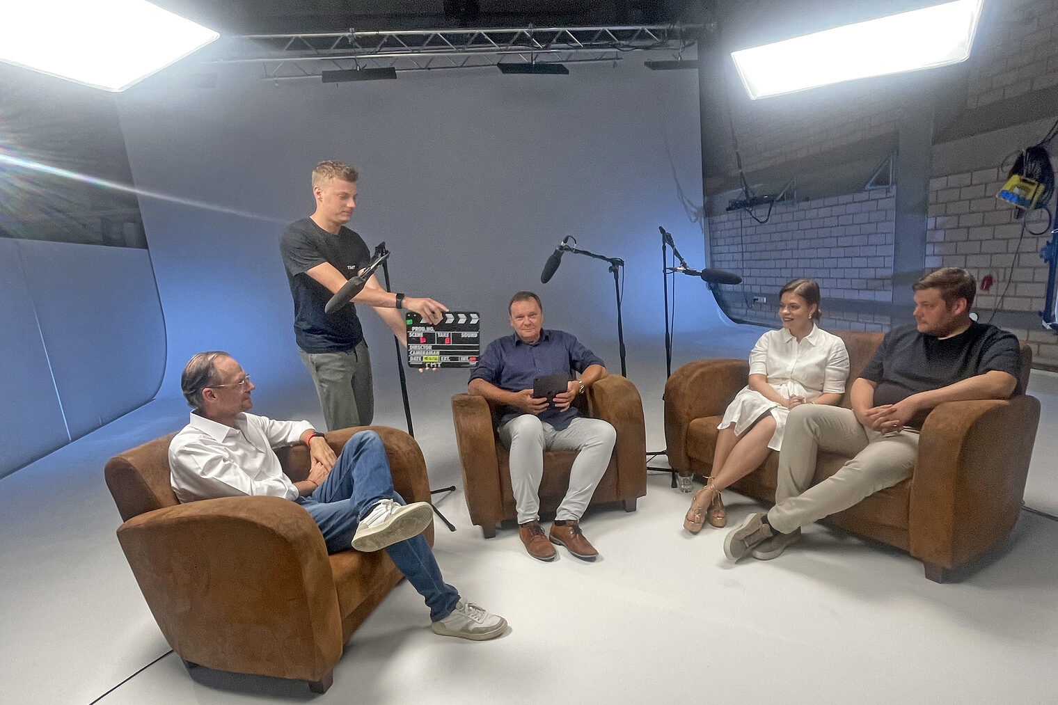 Andreas Fickenscher, Frank Ebert, Madlen Häckel und Domenik Alex sitzen während einer Aufnahme im Podcaststudio. 