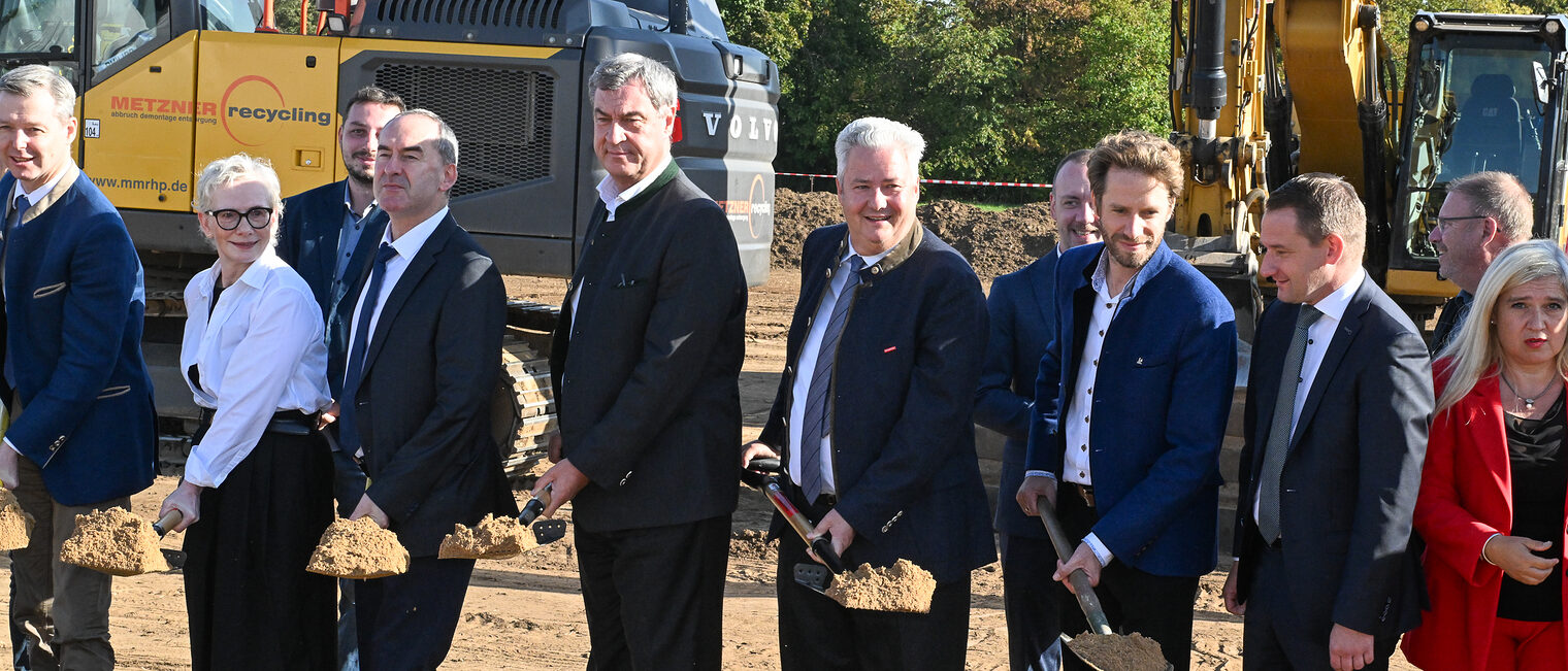 Markus Söder, Hubert Aiwanger, Petra Bahr, Matthias Graßmann, Sebastian Niedermaier und weitere Ehrengäste machen gemeinsam den ersten Spatenstich.