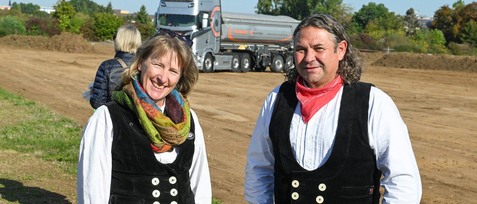 Zwei Handwerker stehen auf der Baustelle nebeneinander.