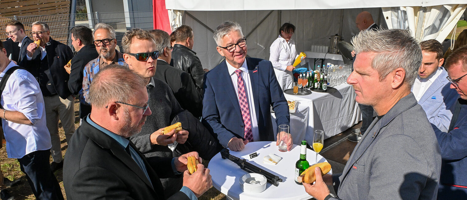 Jens Beland, Marco Kemnitzer und Christian Herpich stehen an einem Stehtisch und unterhalten sich. 
