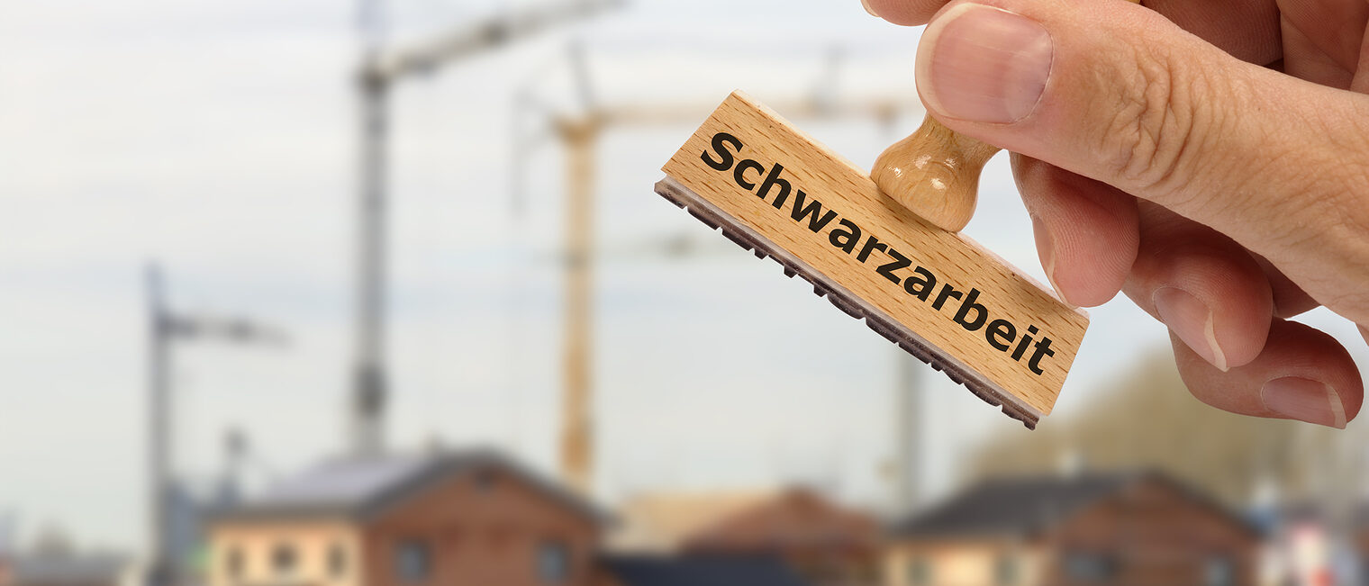 Stempel mit Schwarzarbeit vor einer Baustelle