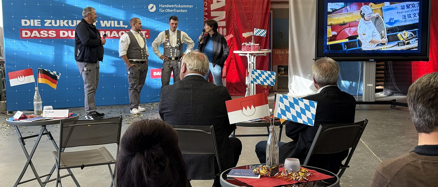 Tim Arnold und Jakob Distler werden von Michaela Heimpel interviewt, während das Publikum zusieht.
