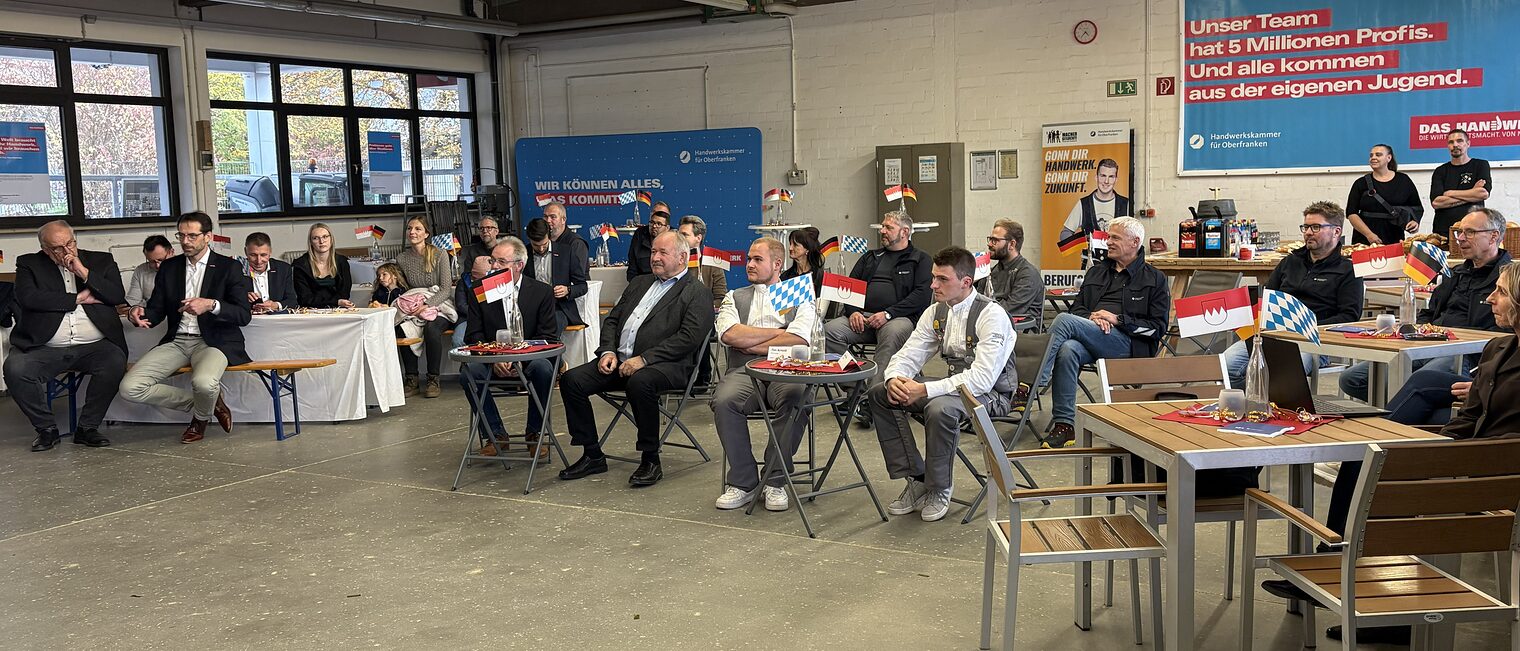 Die Besucher der Feier sitzen in der Bauhalle der HWK.