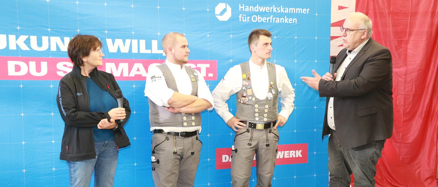 Reinhard Bauer gratuliert den Weltmeistern Tim Arnold und Jakob Distler zu ihrem Erfolg.