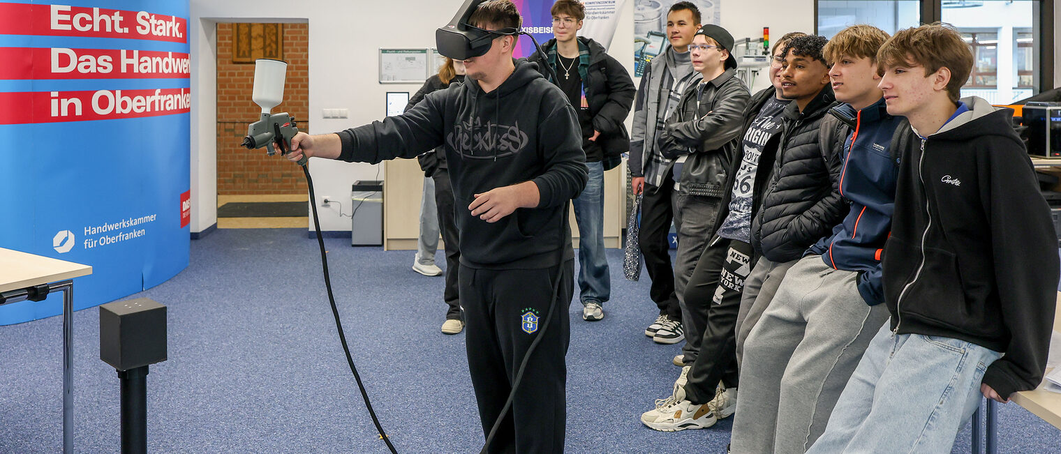 Eine Gruppe Jugendlicher lackiert digital mit VR-Brillen.