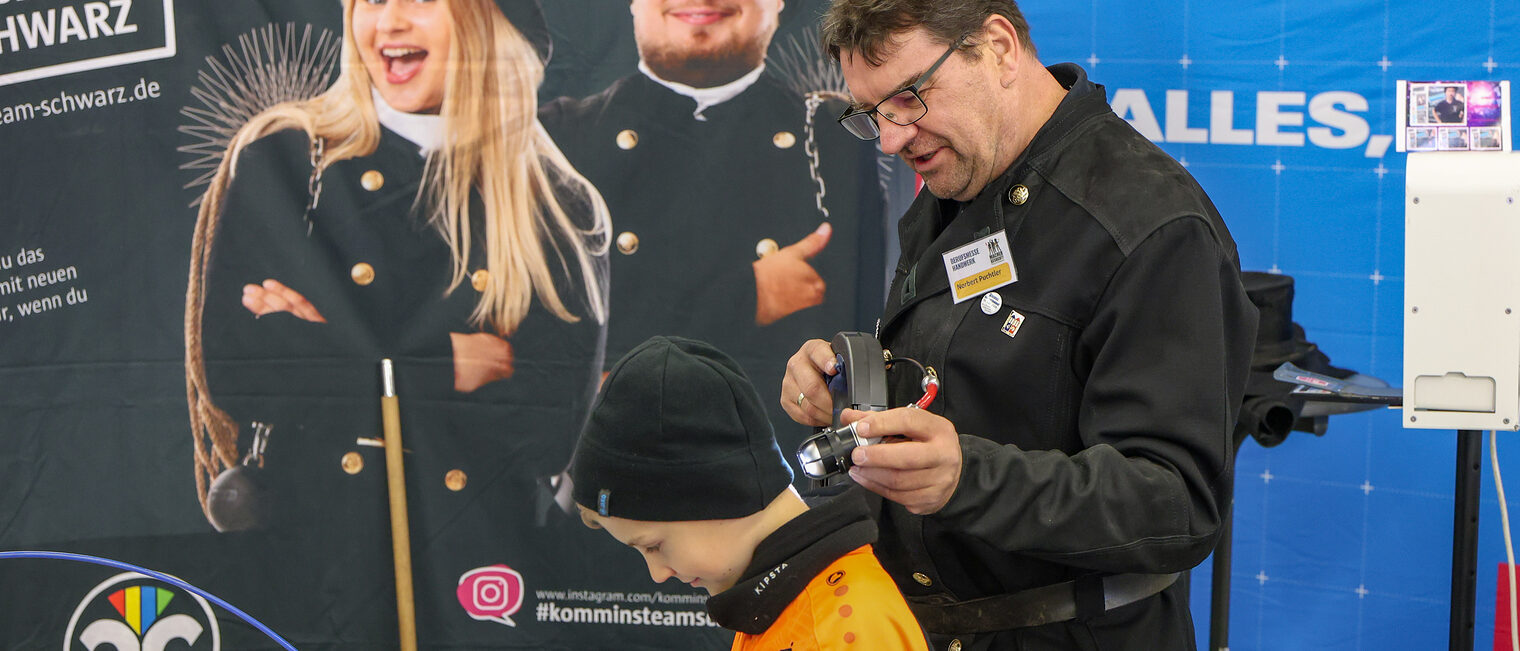 Ein Jugendlicher testet unter Anleitung eine Schornsteinfegerkamera.