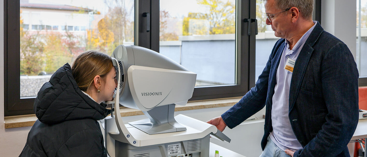 Eine Jugendliche macht unter Anleitung einen Sehtest.