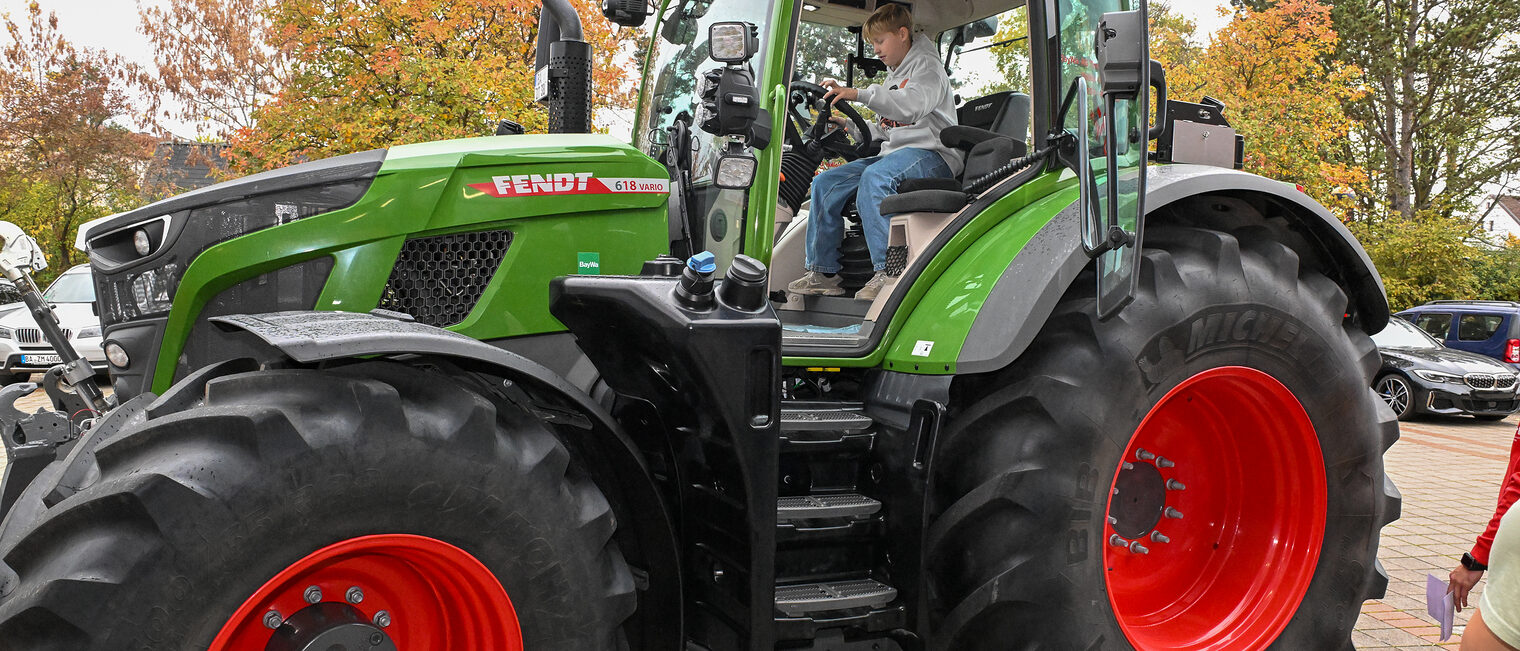 Ein Jugendlicher sitzt in einem Traktor.