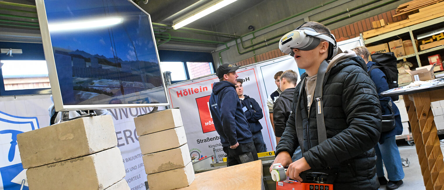 Ein Jugendlicher mit VR-Brille arbeitet auf einer virtuellen Baustelle.