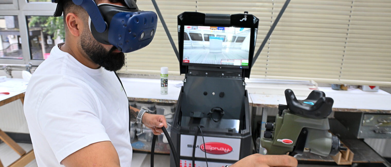 Ein Jugendlicher mit VR-Brille und Farbpistole besprüht digital einen Wagen.
