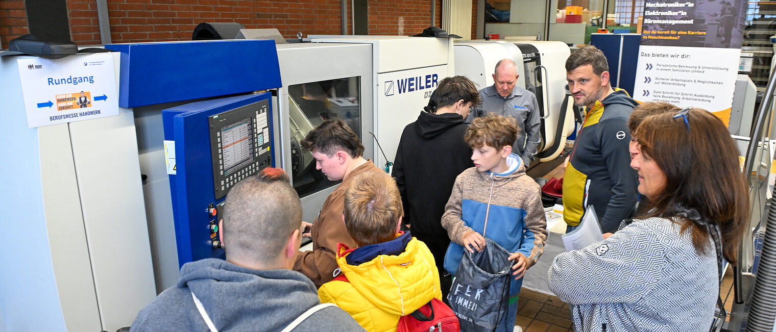 Jugendliche sehen sich Maschinen aus dem Metallbauhandwerk an.