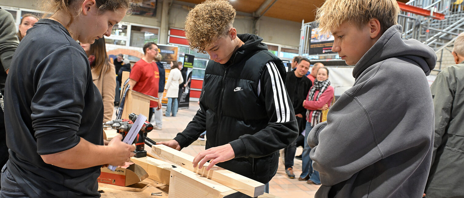 Ein Jugendlicher misst die Länge eines Holzscheites ab.