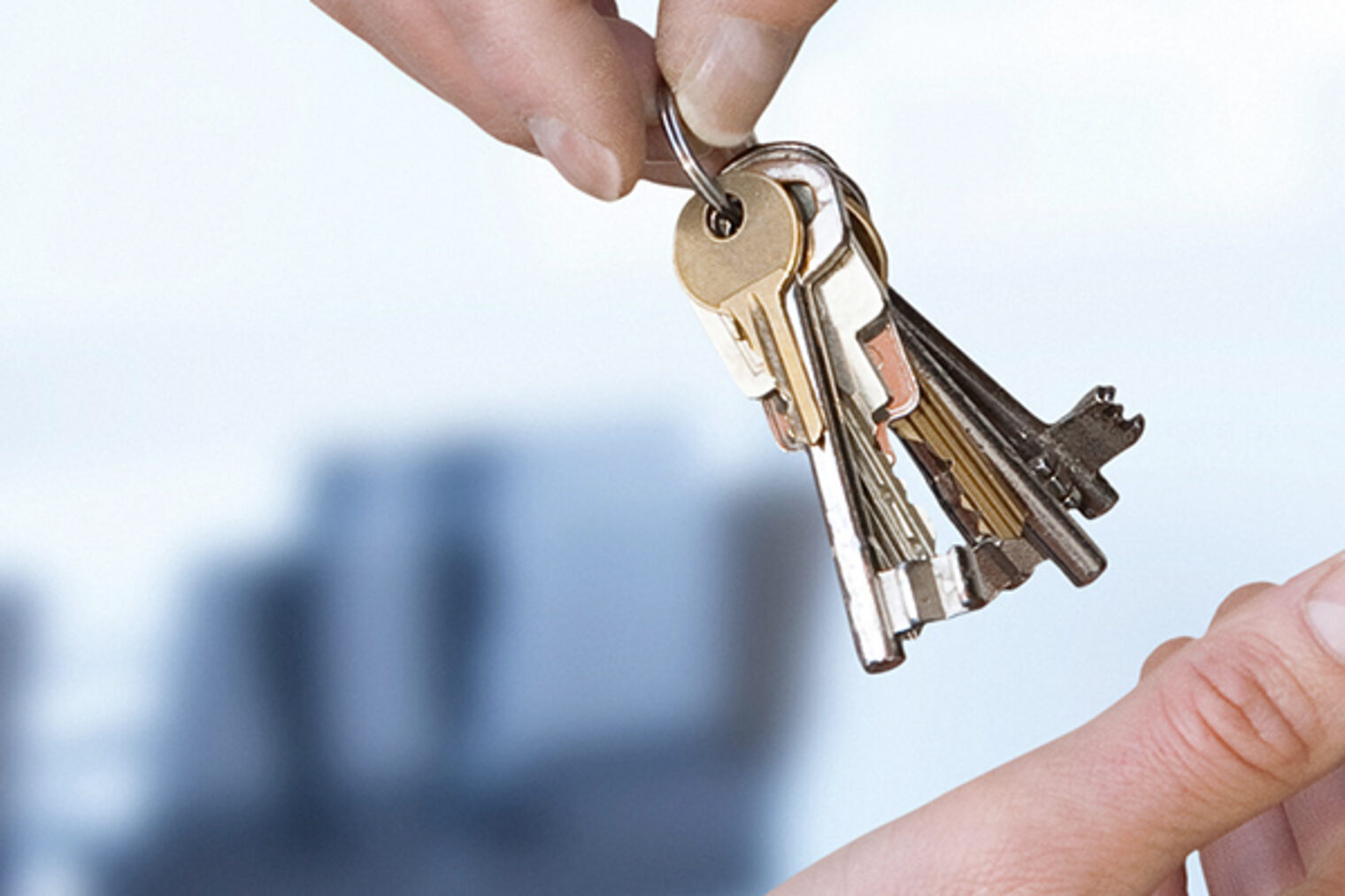 Eine Hand übergibt einen Schlüsselbund an eine andere Hand.