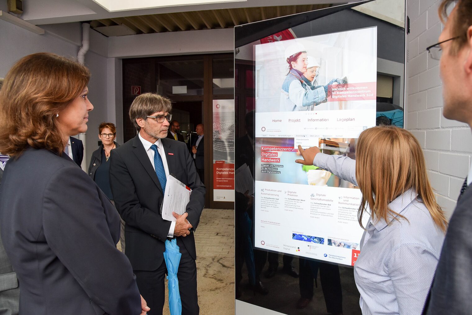 Wie werden die Digitalisierungsfortschritte in die Betriebe transferiert? KDH-Projektleiterin Johanna Erlbacher (rechts) zeigte Bayerns Wirtschaftsministerin Ilse Aigner und HWK-Hauptgeschäftsführer Thomas Koller eine Stele des neuen Innovationspfads an der Kammer.