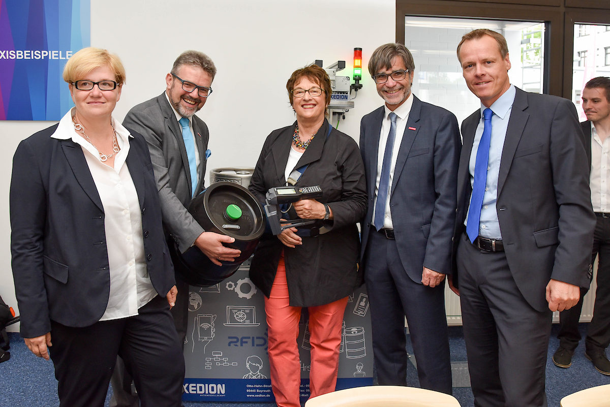 Diese Technik funktioniert auch in einer echten Brauerei: Bundeswirtschaftsministerin Brigitte Zypries (Mitte) scannt den in dem Bierfass eingebauten RFID-Transponder. Gemeinsam mit der Parlamentarischen Staatssekretärin im Bundesarbeitsministerium, MdB Anette Kramme (links), ließ sich Zypries von HWK-Präsident Thomas Zimmer und HWK-Hauptgeschäftsführer Thomas Koller (von links) die Arbeit des KDH erklären.