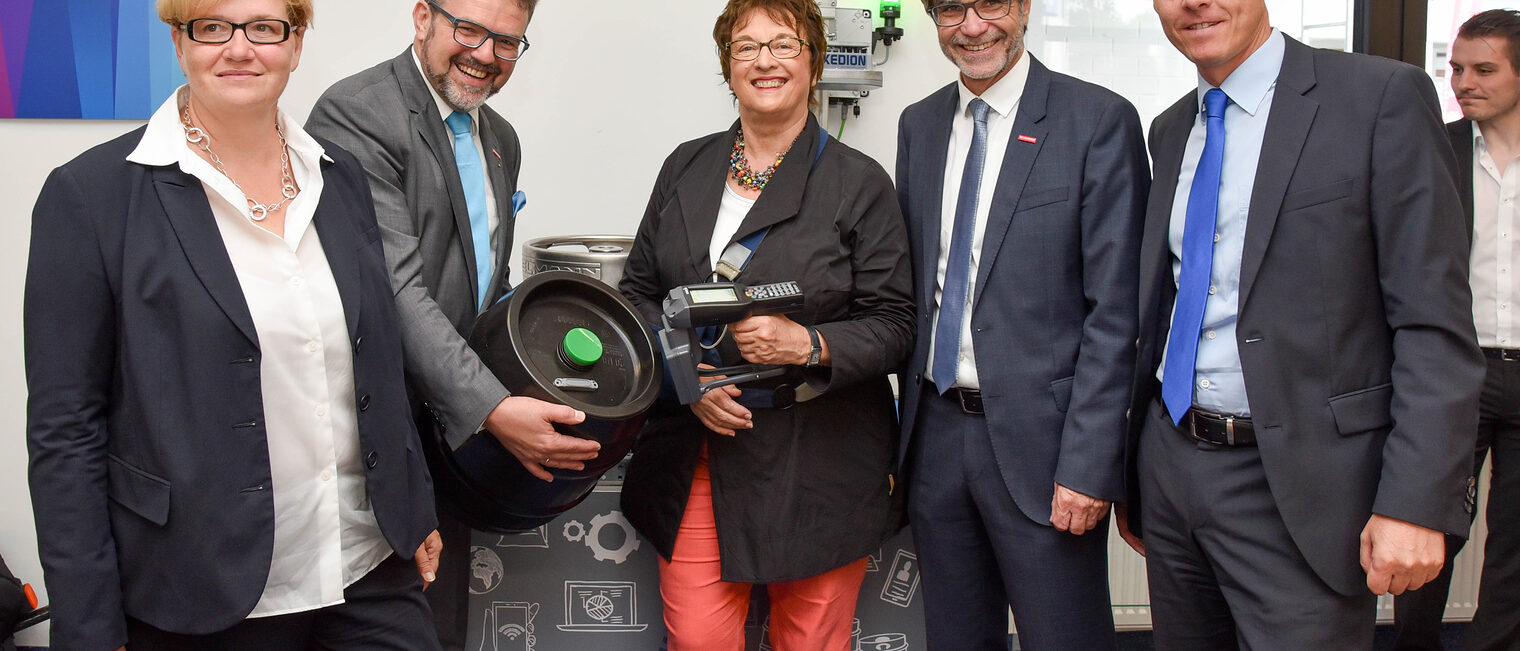 Diese Technik funktioniert auch in einer echten Brauerei: Bundeswirtschaftsministerin Brigitte Zypries (Mitte) scannt den in dem Bierfass eingebauten RFID-Transponder. Gemeinsam mit der Parlamentarischen Staatssekretärin im Bundesarbeitsministerium, MdB Anette Kramme (links), ließ sich Zypries von HWK-Präsident Thomas Zimmer und HWK-Hauptgeschäftsführer Thomas Koller (von links) die Arbeit des KDH erklären.