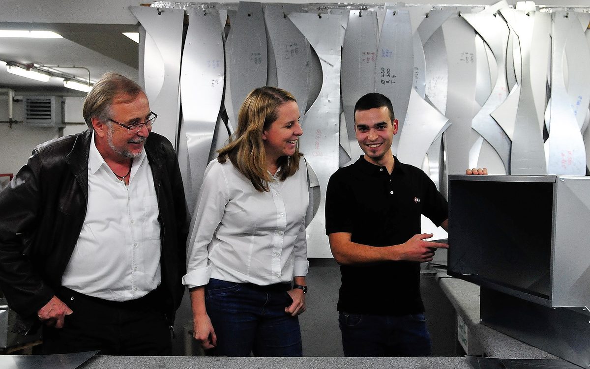 Der ungarische Bundessieger Balazs Kis (rechts) zeigt den Geschäftsführern Elke Rieß und Helmut Fuchs den Aufbau einer Luftkanaldämmung.