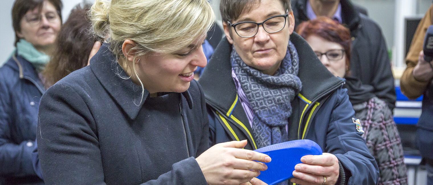 Die Vorsitzende der Landtagsfraktion von Bündnis 90/Die Grünen, Katharina Schulze, und die Bayreuther Landtagsvizepräsidentin Ulrike Gote (rechts) begutachten eine Einlage, die im 3D-Drucker hergestellt wurde. 