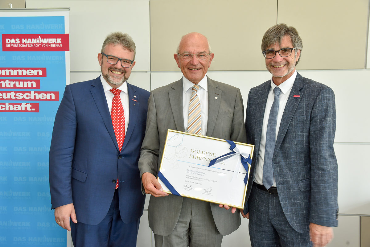 HWK-Präsident Thomas Zimmer (links) und HWK-Hauptgeschäftsführer Thomas Koller (rechts) zeichneten Bezirkstagspräsident Dr. Günther Denzler mit der Goldenen Ehrennadel mit Urkunde der HWK für Oberfranken aus. HWK-Präsident Thomas Zimmer (links) und HWK-Hauptgeschäftsführer Thomas Koller (rechts) zeichneten Bezirkstagspräsident Dr. Günther Denzler mit der Goldenen Ehrennadel mit Urkunde der HWK für Oberfranken aus.