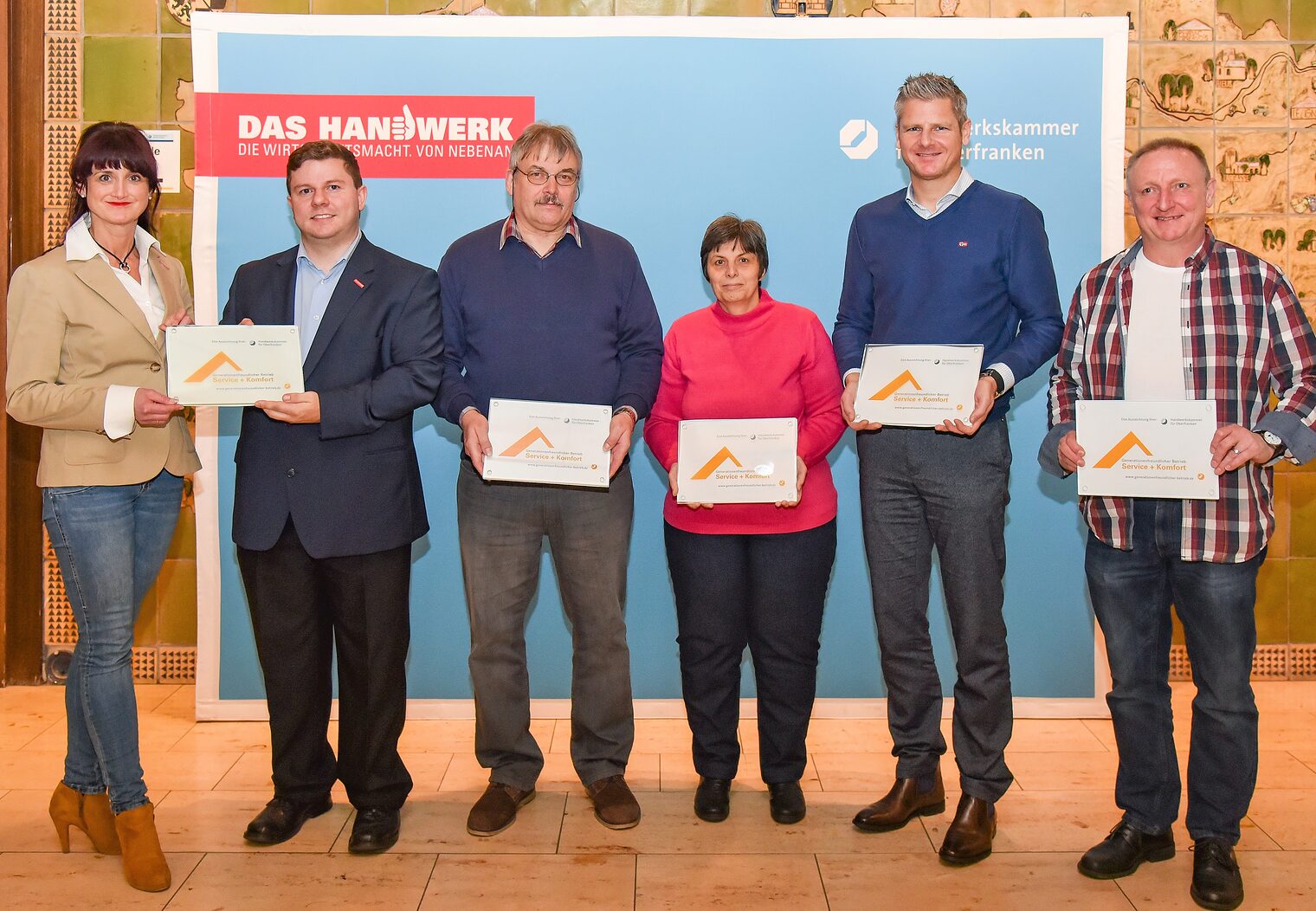 Die Leiterin des BTZ Bayreuth der HWK für Oberfranken, Alexandra Reuther, und der Leiter des Projekt "9 x selbstbestimmt Wohnen in Oberfranken" an der HWK, Alexander Hader, übergaben an Heribert Schmitt und Erika Peterssen (beide HS Hausmeisterdienste), Marco Kemnitzer (WEGGEL Haustechnik GmbH, Kemnitzer GmbH) und Volker Kiesling (VK Hausmeisterdienste) das Glassiegel "Generationenfreundlicher Betrieb für Service + Komfort" (von links).