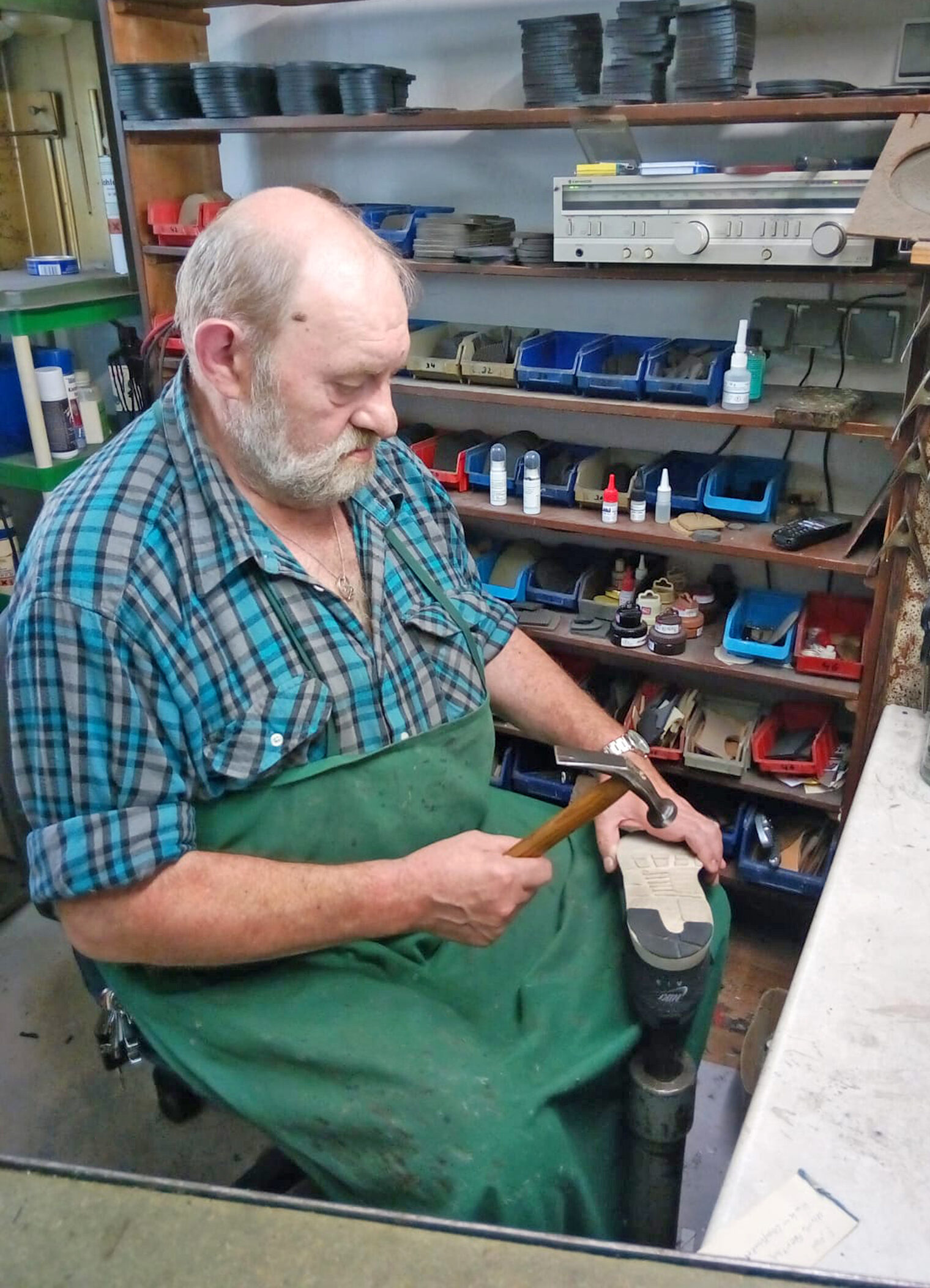Orthopädie-Schuhmacher Franz Hofmann klopft eine Sohle an einem Schuh fest.