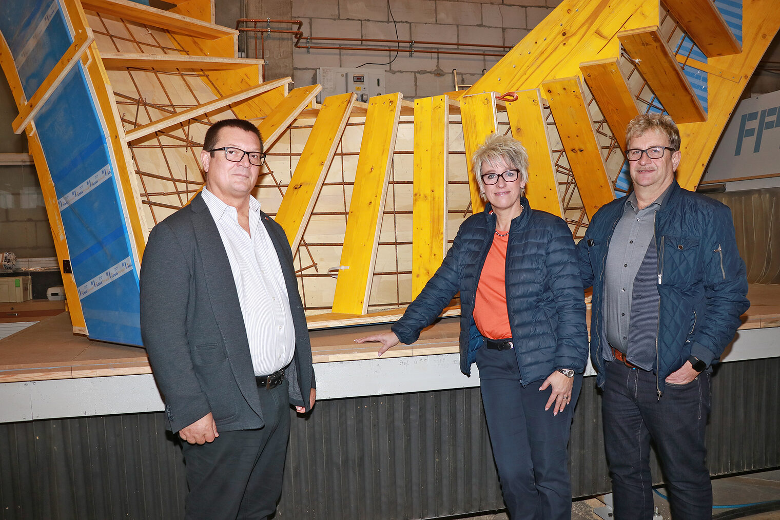 HWK-Berater Dieter Opel, Geschäftsführerin Sonja Jesenik und Schreinermeister Robert Loibl stehen vor einer Treppenschalung.