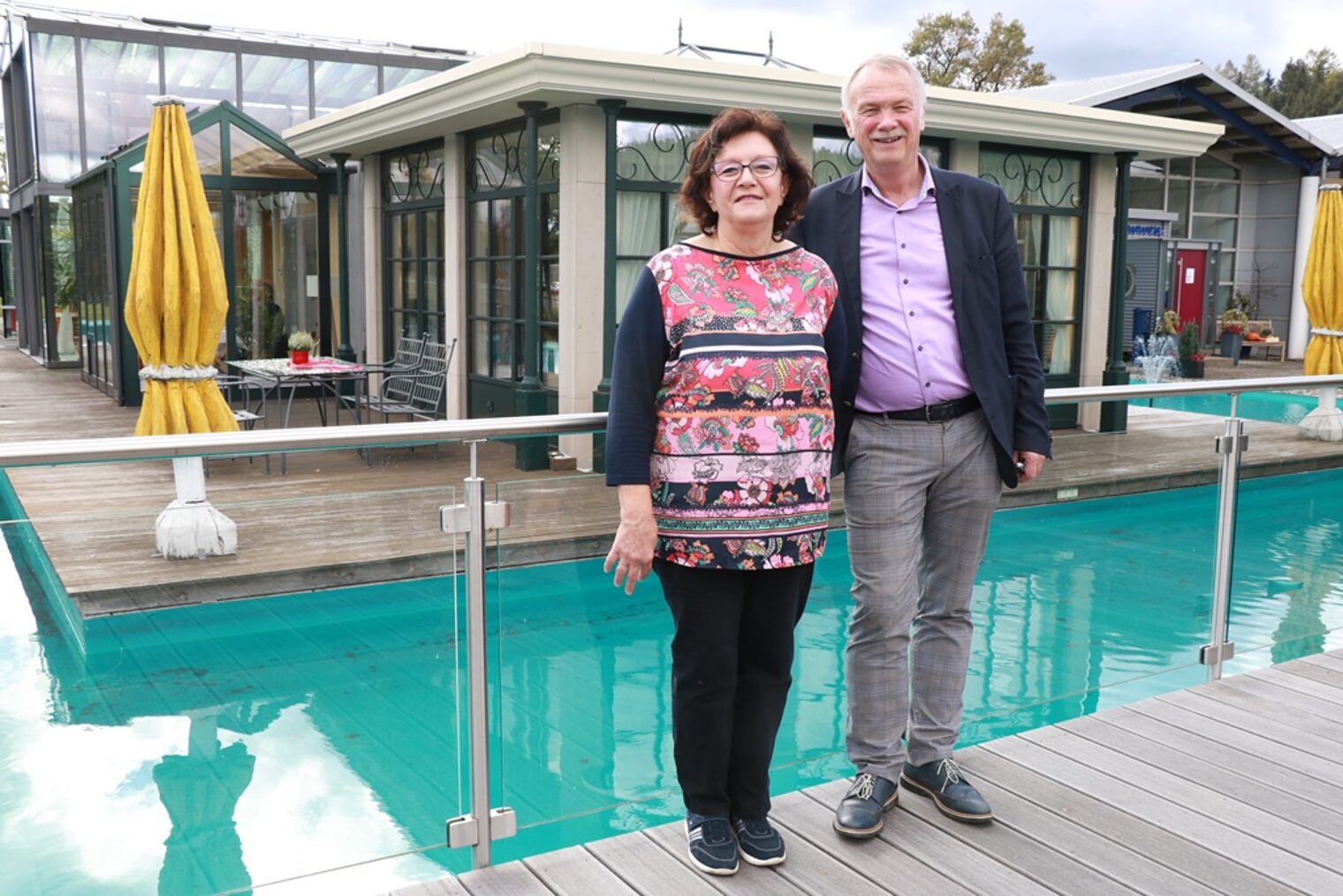 Geschäftsführer Herbert Baumann und seine Ehefrau stehen vor einem Beispielwintergarten.