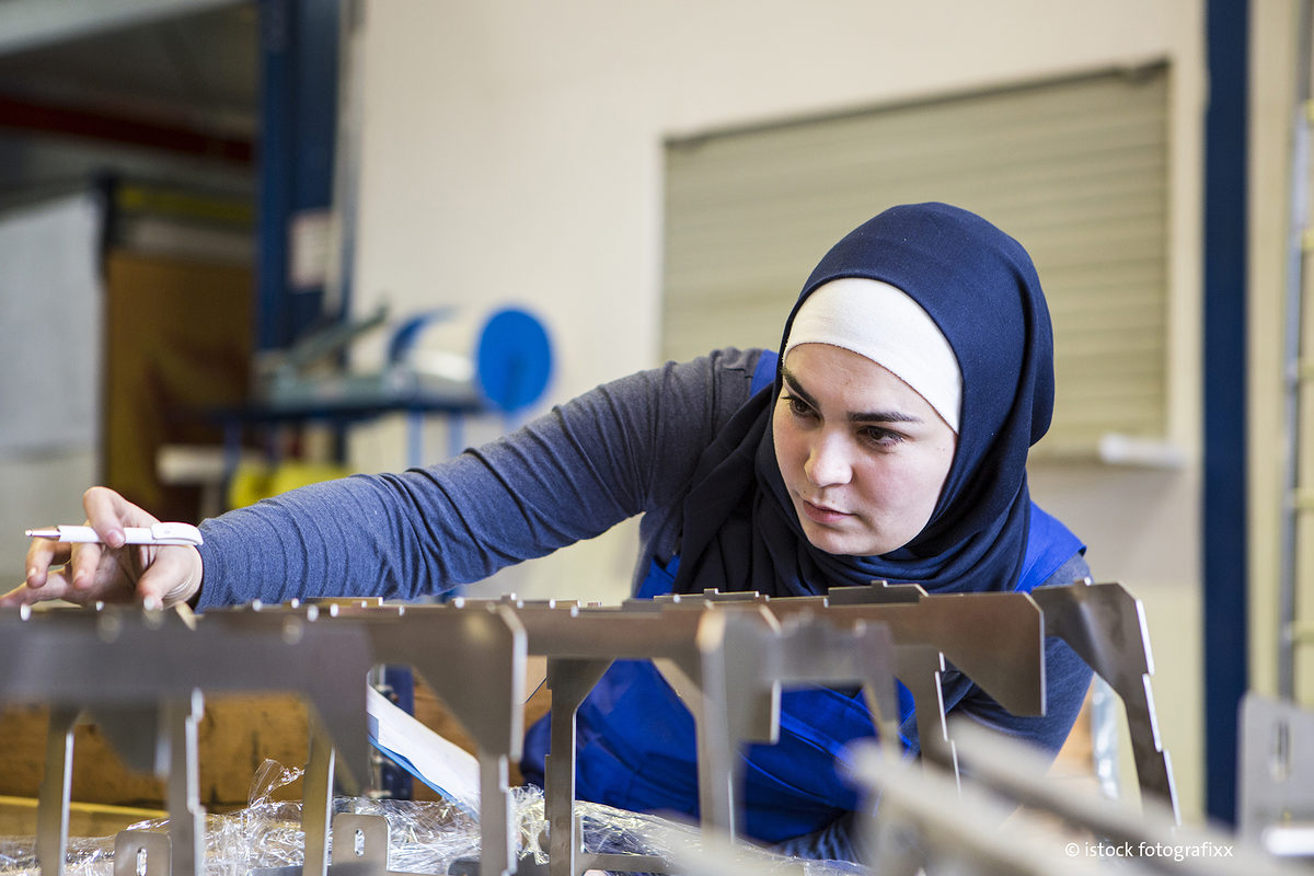 Young female trainee makes a quality control of metal pieces