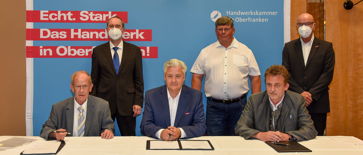 Bayerns Wirtschaftsminister Hubert Aiwanger, Vorstandsmitglied Michael Klein und der Leiter des Verwaltungssitzes Coburg der HWK für Oberfranken, Dr. Hans-Karl Bauer (stehend von links), begleiteten die Vertragsunterzeichnung zwischen den Sprechern des Coburger Handwerks, Knut von Berg (sitzend links) und Rocco Müller (sitzend rechts), und HWK-Präsident Matthias Graßmann. Bayerns Wirtschaftsminister Hubert Aiwanger, Vorstandsmitglied Michael Klein und der Leiter des Verwaltungssitzes Coburg der HWK für Oberfranken, Dr. Hans-Karl Bauer (stehend von links), begleiteten die Vertragsunterzeichnung zwischen den Sprechern des Coburger Handwerks, Knut von Berg (sitzend links) und Rocco Müller (sitzend rechts), und HWK-Präsident Matthias Graßmann.